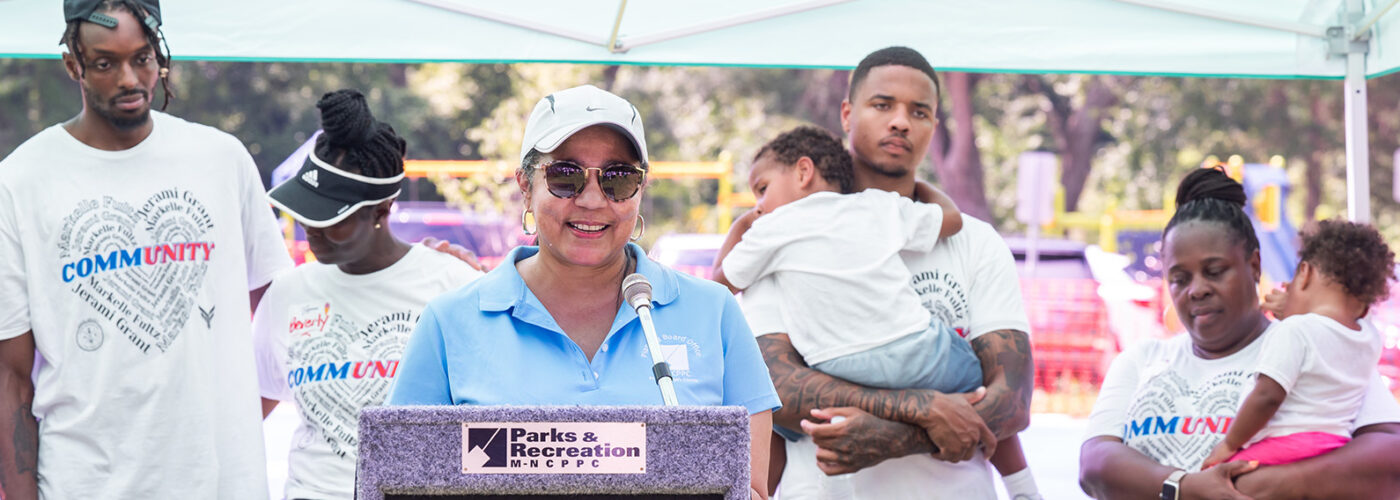 Jesse J Warr, Jr KABOOM Sports Court Build speaker with blackfamily behind her